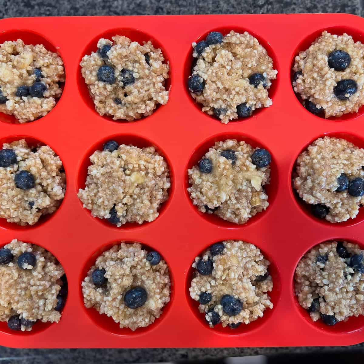 Blueberry millet muffin batter in silicone muffin pan.