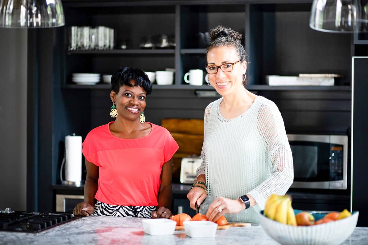 two women standing in the kitchen smiling