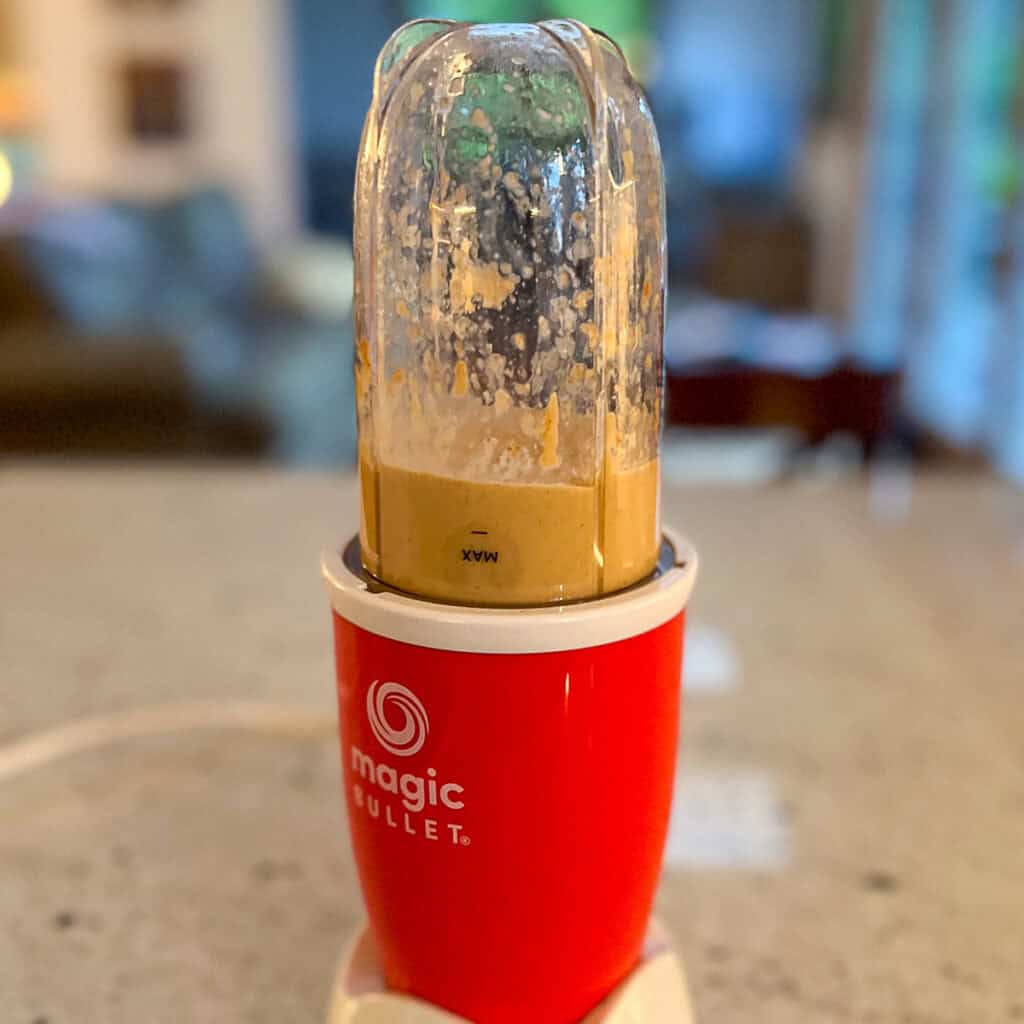 Vegan sriracha mayo being blended in a bullet blender.