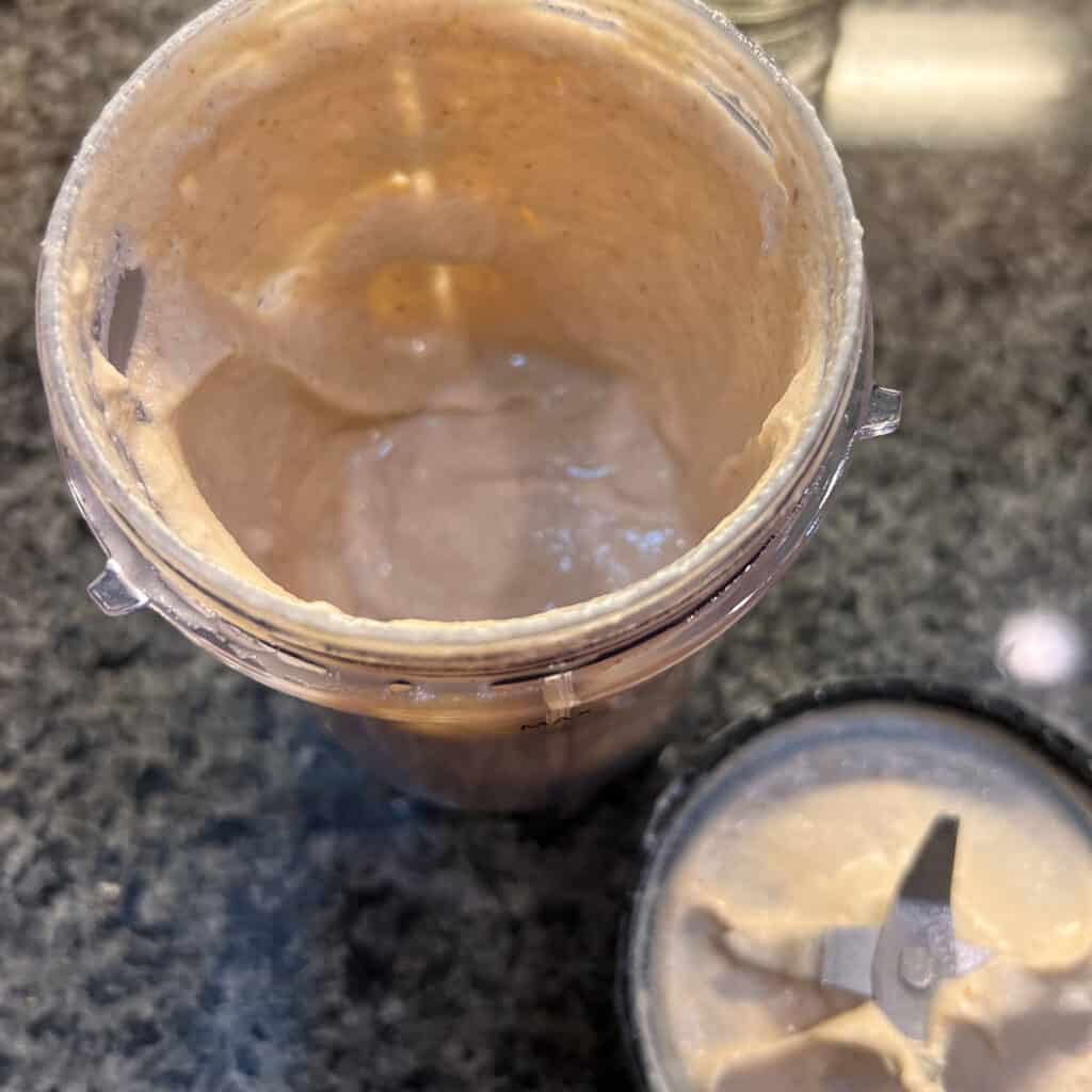 A mini blender container with sweet cashew cream after being blended.