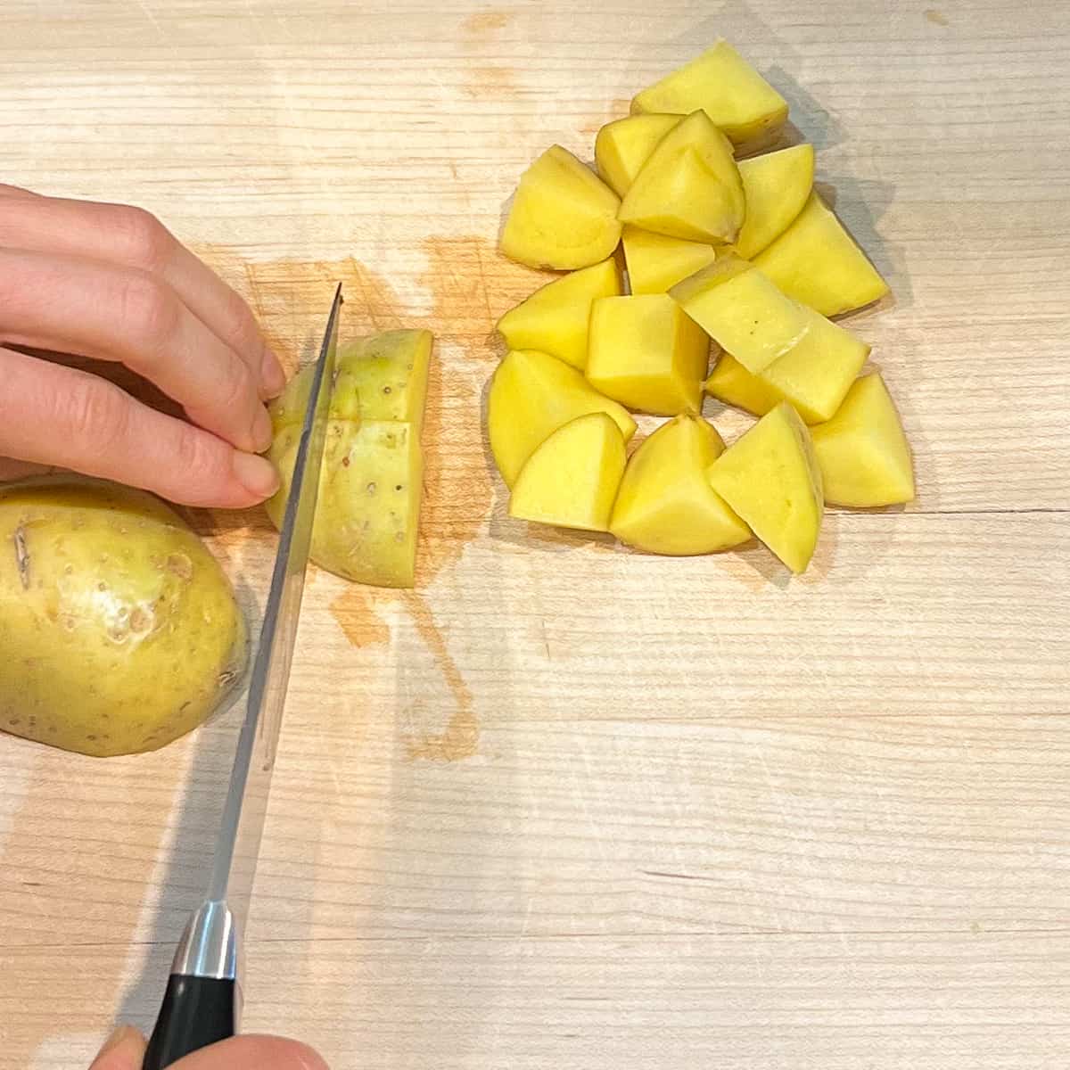 woman's hand chopping potatoes