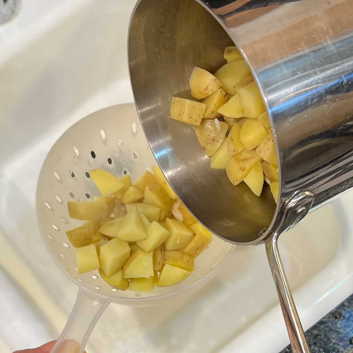 a colander with cooked potatoes straining off water