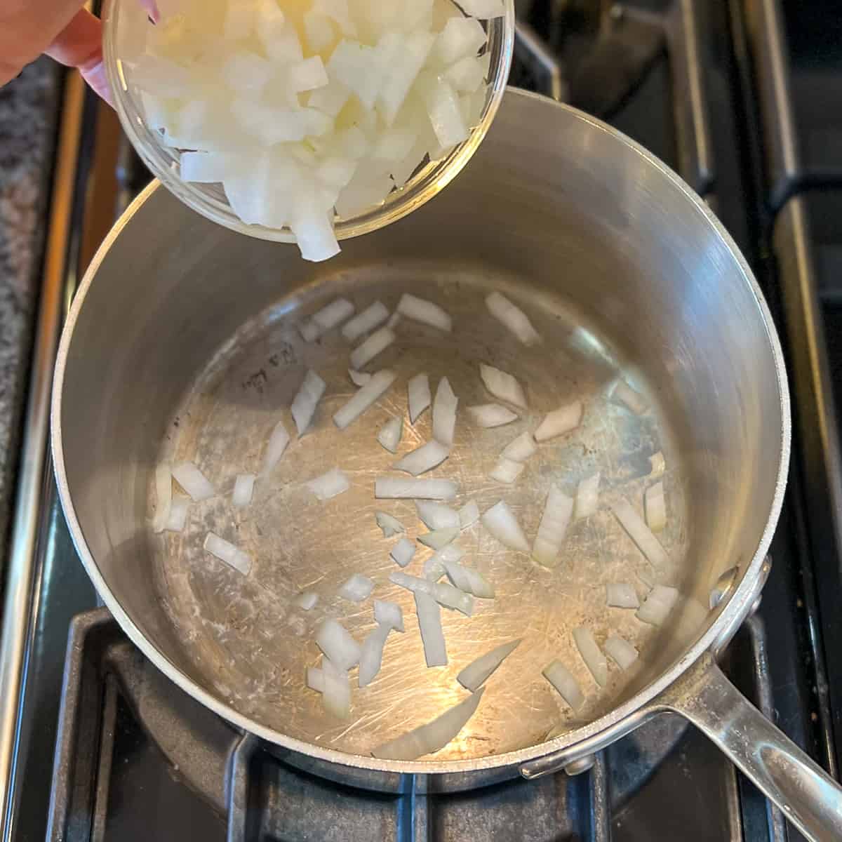 top view of diced onions being added to the pot