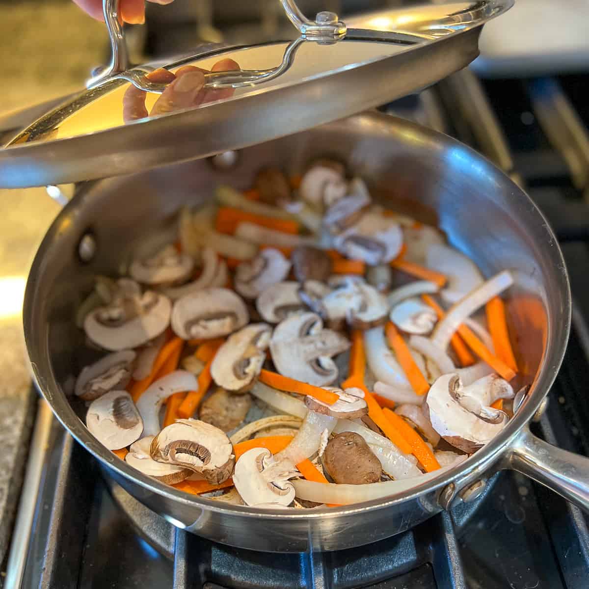 top view of lid being placed on pan with veggies