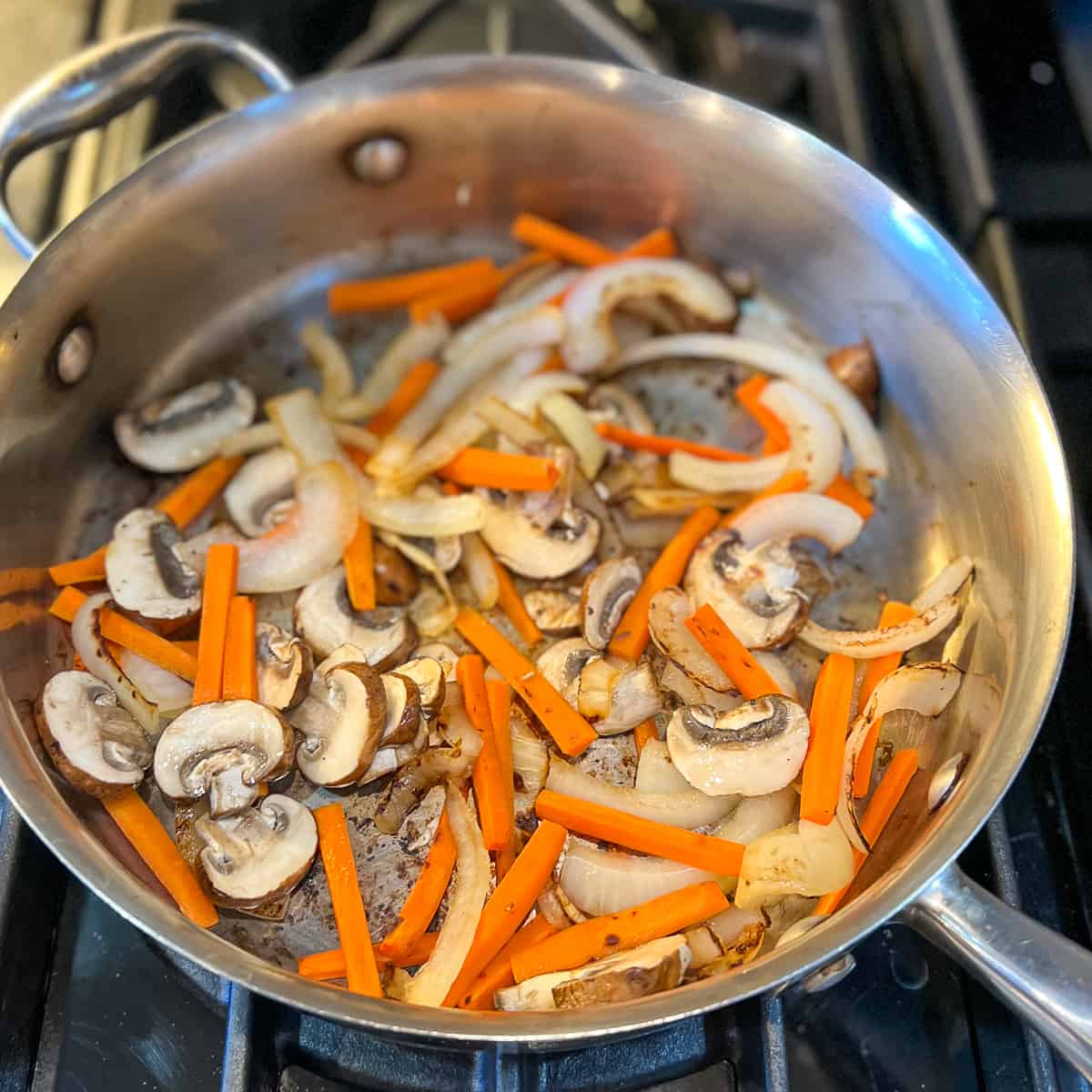 top view of pan with sautéed mushrooms, onions and carrots