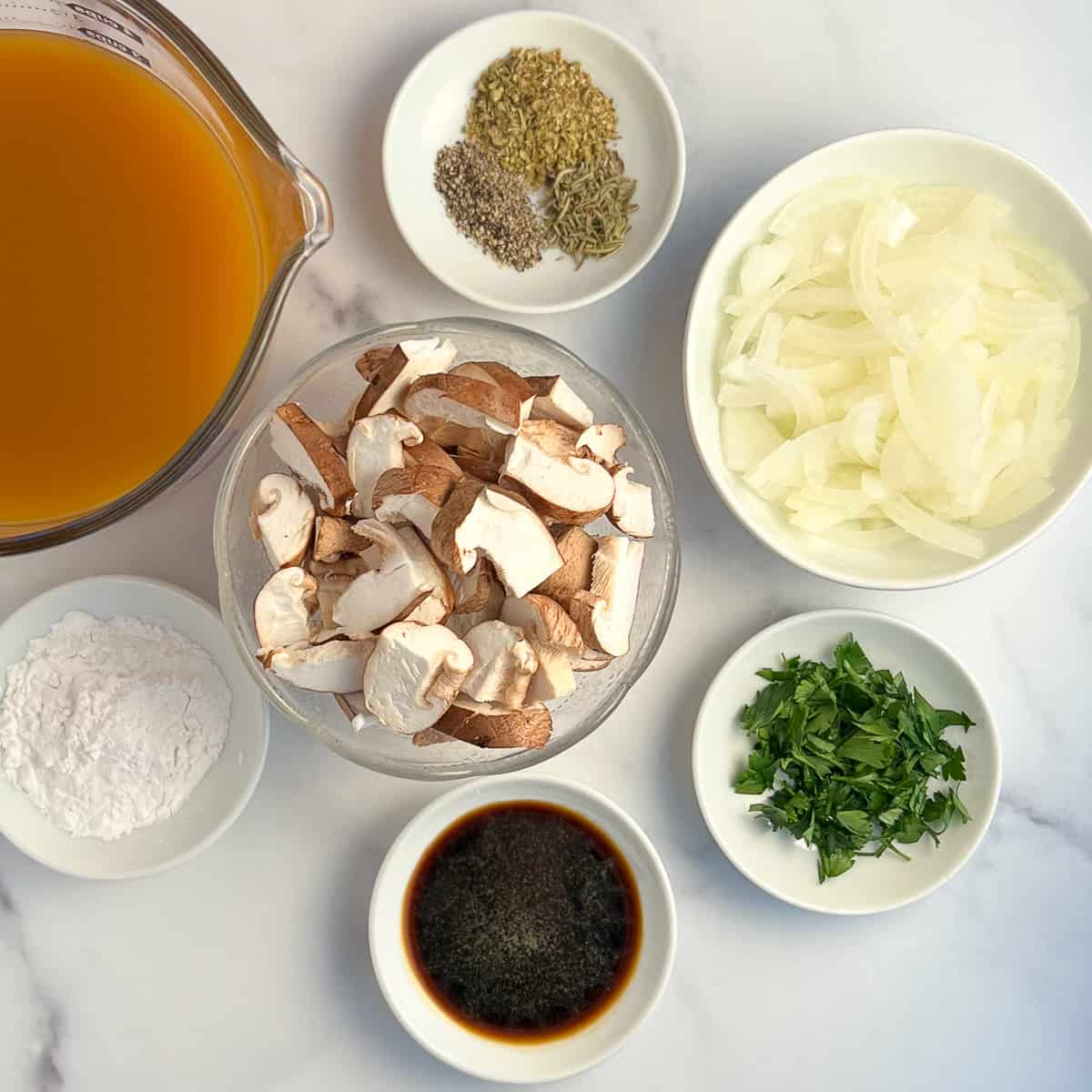 top view of key ingredients: mushrooms, onion, coconut aminos, arrowroot powder, spices, low sodium vegetable broth, fresh parsley