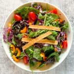 Southwestern salad in a bowl topped with corn tortilla strips.