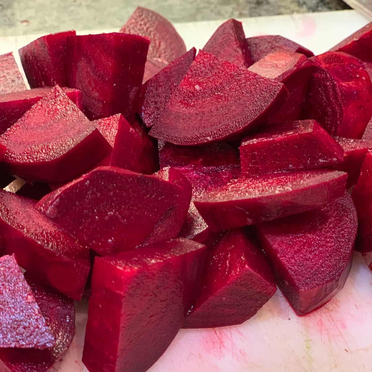 top side view close up of a pile of chopped beets on a cutting board