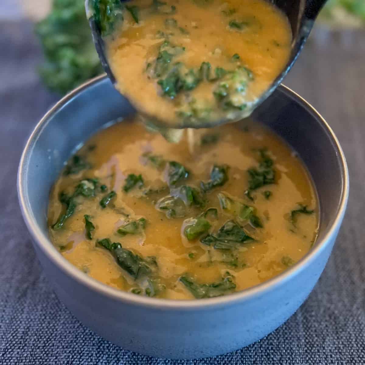 side top view of blue bowl with creamy white bean kale soup