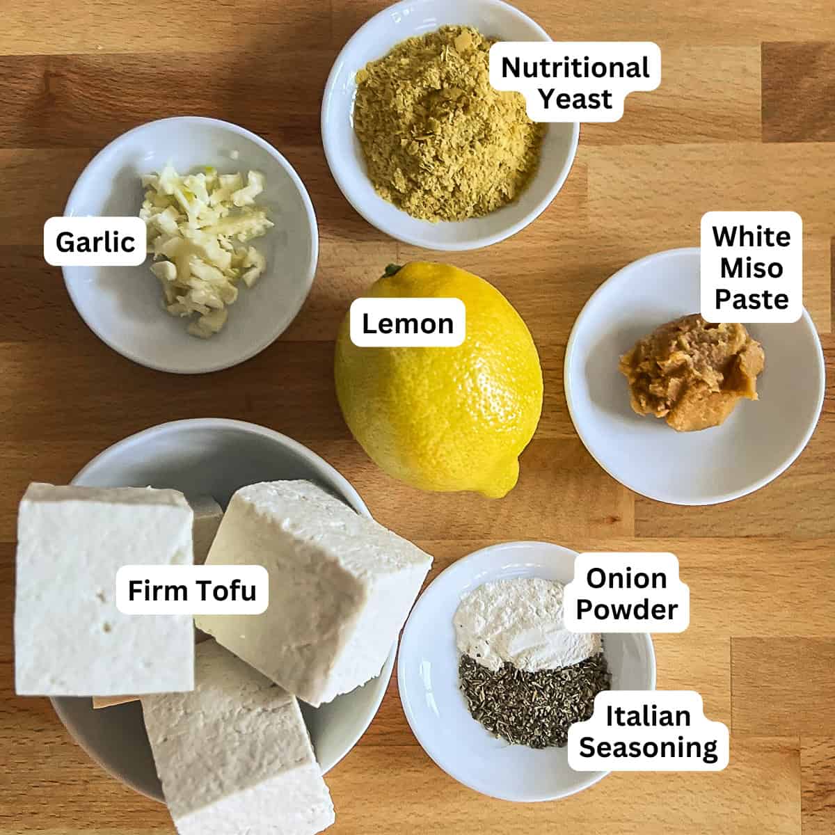 The key ingredients for tofu ricotta: tofu, lemon, minced garlic, nutritional yeast, miso paste, dried Italian seasoning and onion powder.