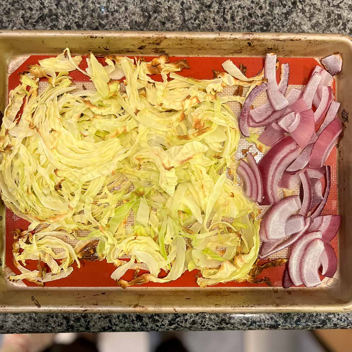 top view of finely chopped cabbage and red onions on a sheet pan