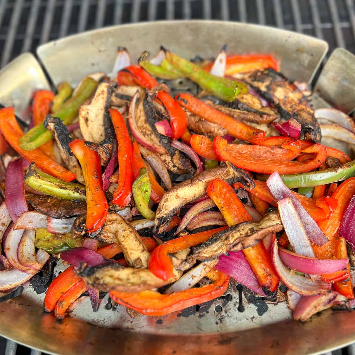 top side view close up of grilled mushrooms, peppers and onions in a grill pan