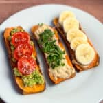 top view of three sweet potato toasts on a white plate with different toppings
