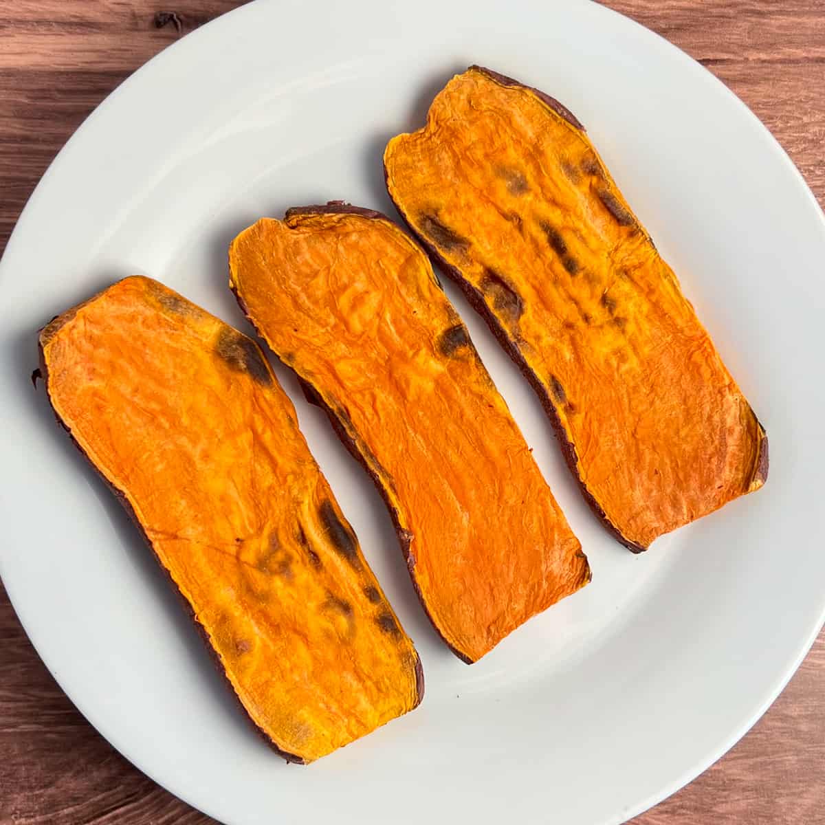 top view of 3 slices of sweet potato toast on a white plate that have been toasted in the toaster and are ready for topping