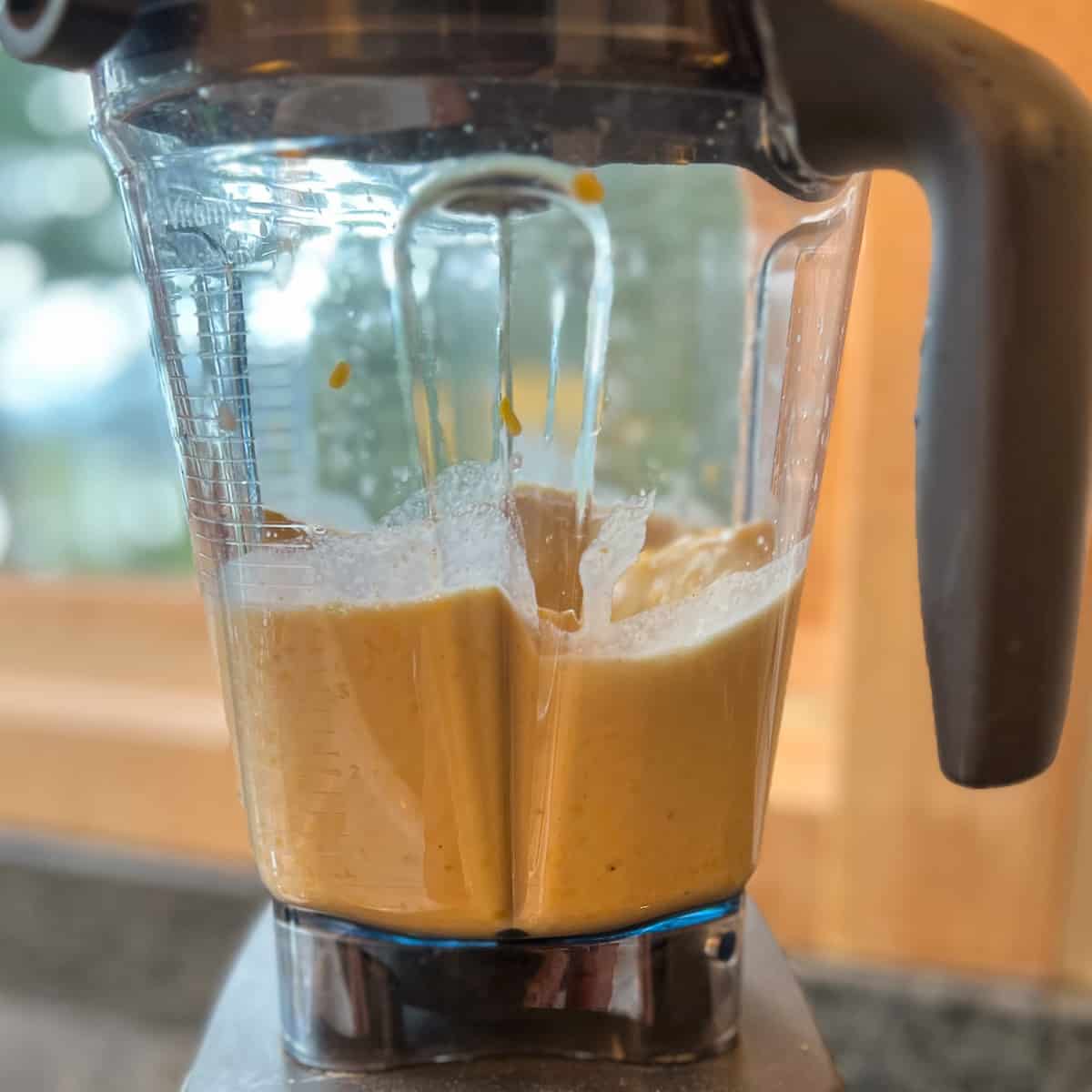 side view of blended yellow mung bean "egg" mixture in a blender