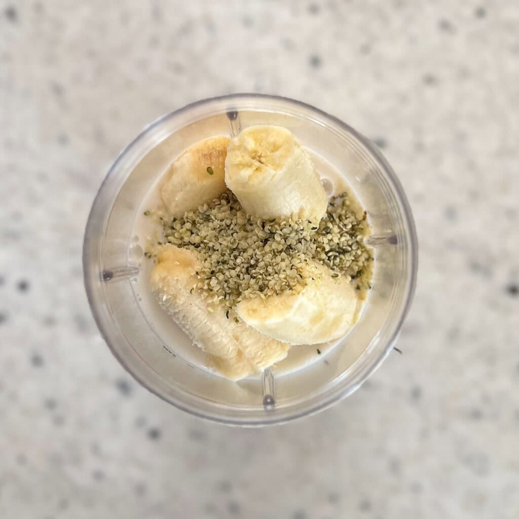 Ingredients for peach banana smoothie in a blender cup.