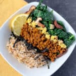 top view close up of nori maki bowl with brown rice, kale with mushrooms, fresh ginger and lemon wedge