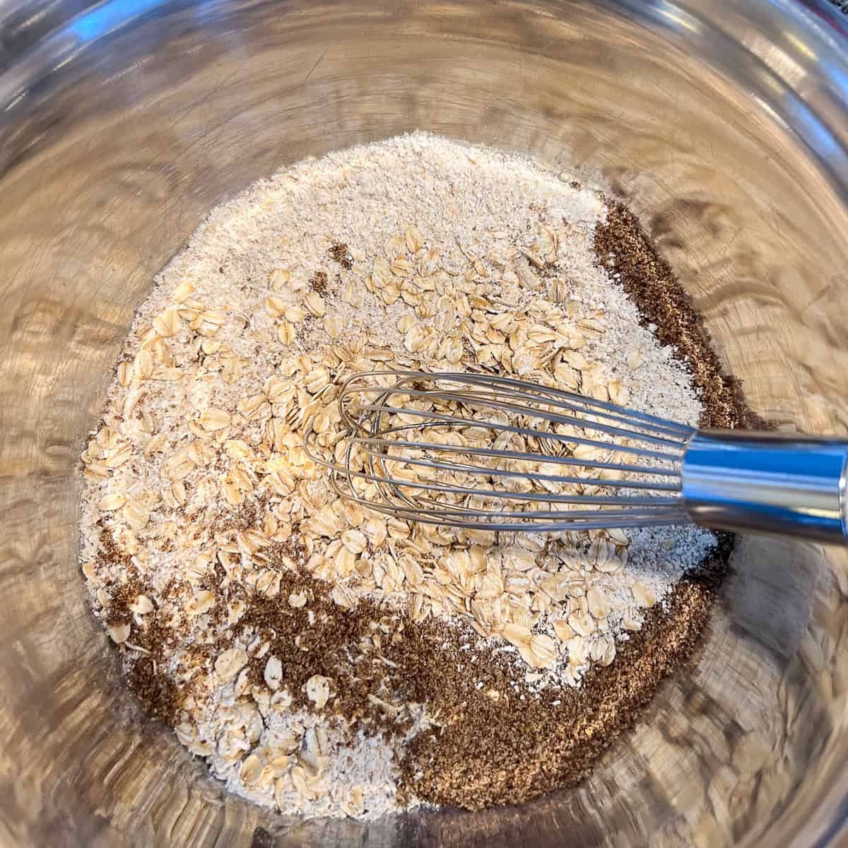 top view of dry ingredients in a mixing bowl with whisk