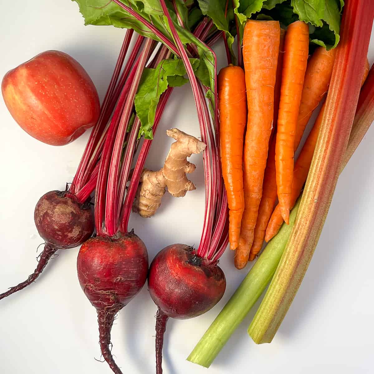 top view of ingredients for heart healthy juice: carrot beet apple ginger and rhubarb