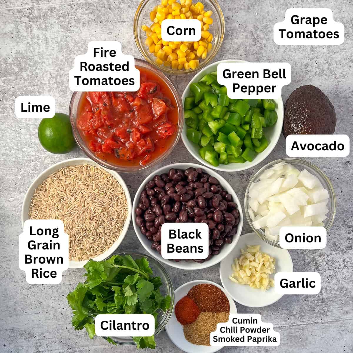 Ingredients for Mexican rice casserole: rice, beans, bell pepper, onions, garlic, spices, cilantro, avocado, lime, diced tomatoes.