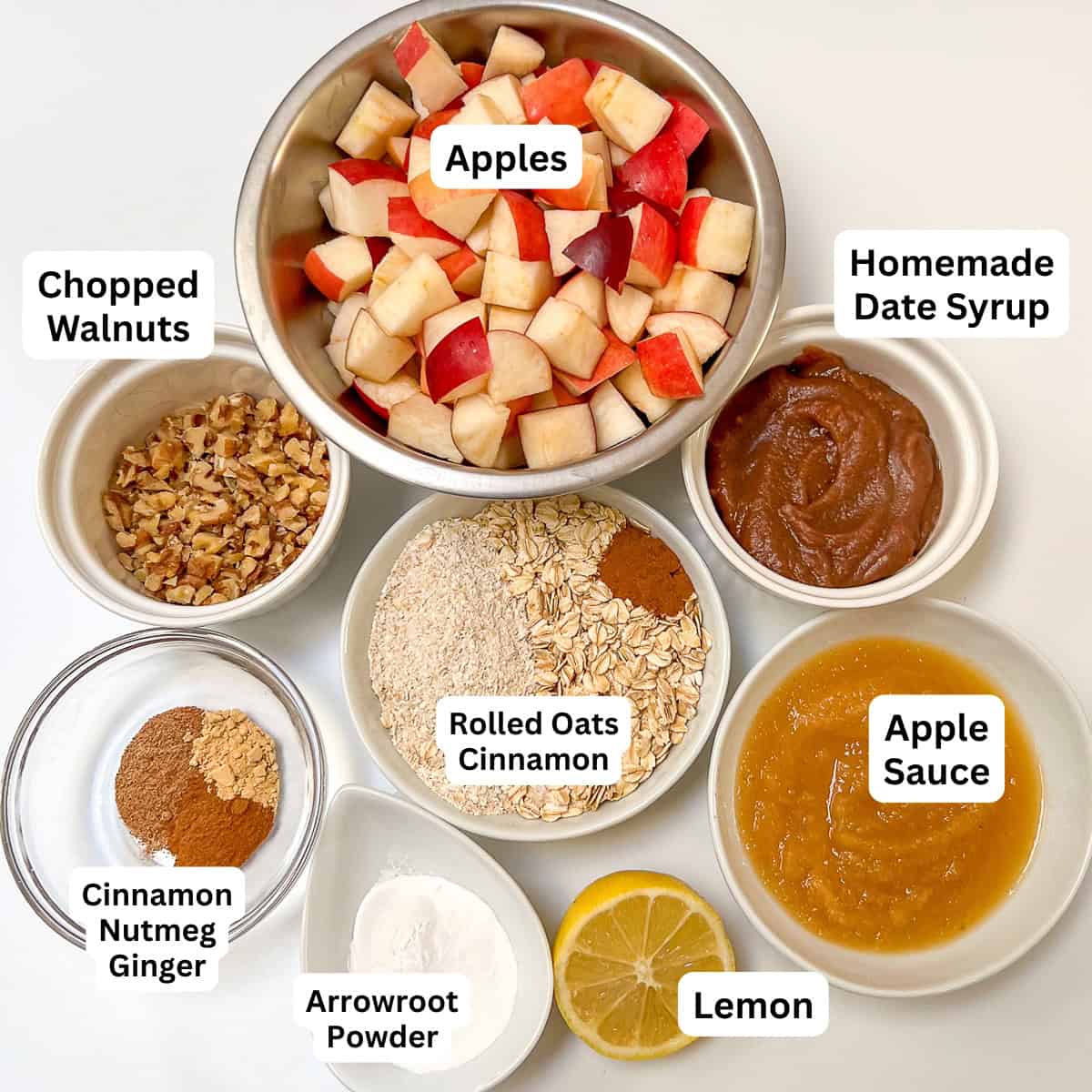 Ingredients for apple crisp: apples, oats, nuts, spices, lemon, date syrup.