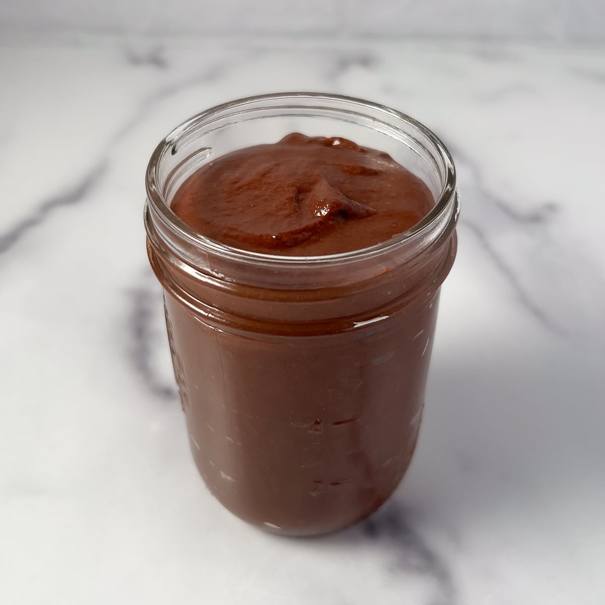 top side view close up of chocolate tahini sauce in a mason jar
