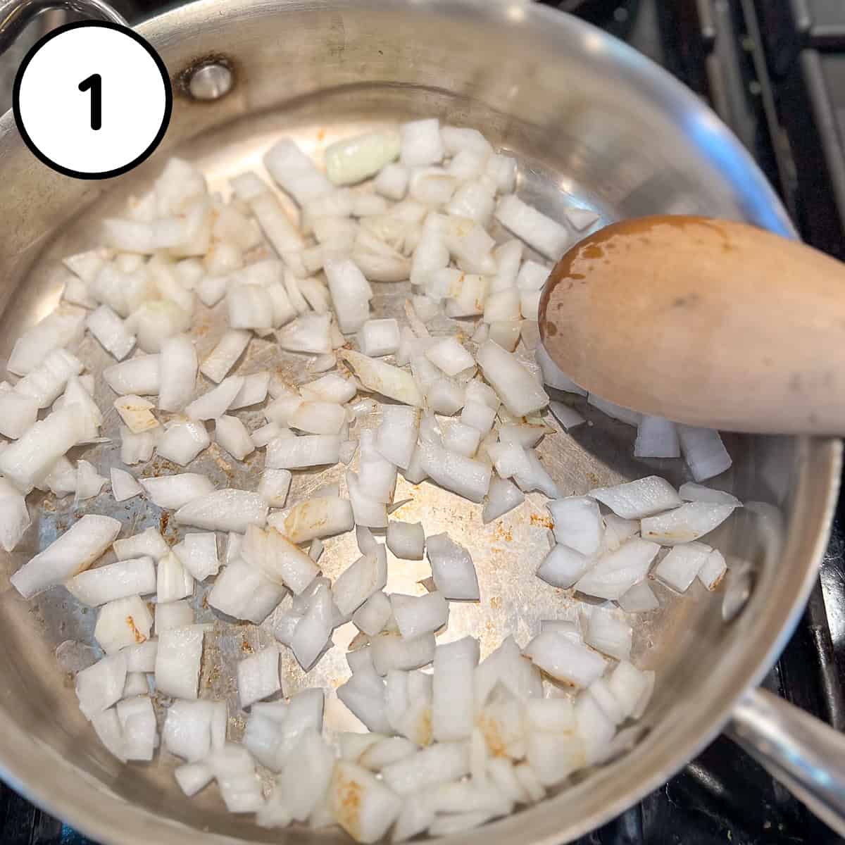 Chopped onions being sautéed in a pan.