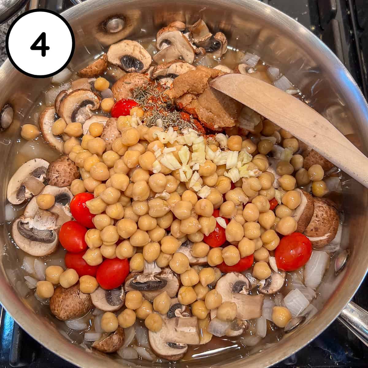 Chickpeas, tomatoes, garlic, miso paste and aquafaba added to the pan.