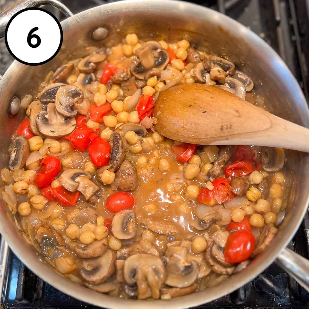 Sauté pan with cooked down tomatoes, mushrooms, and chickpeas in the miso broth.