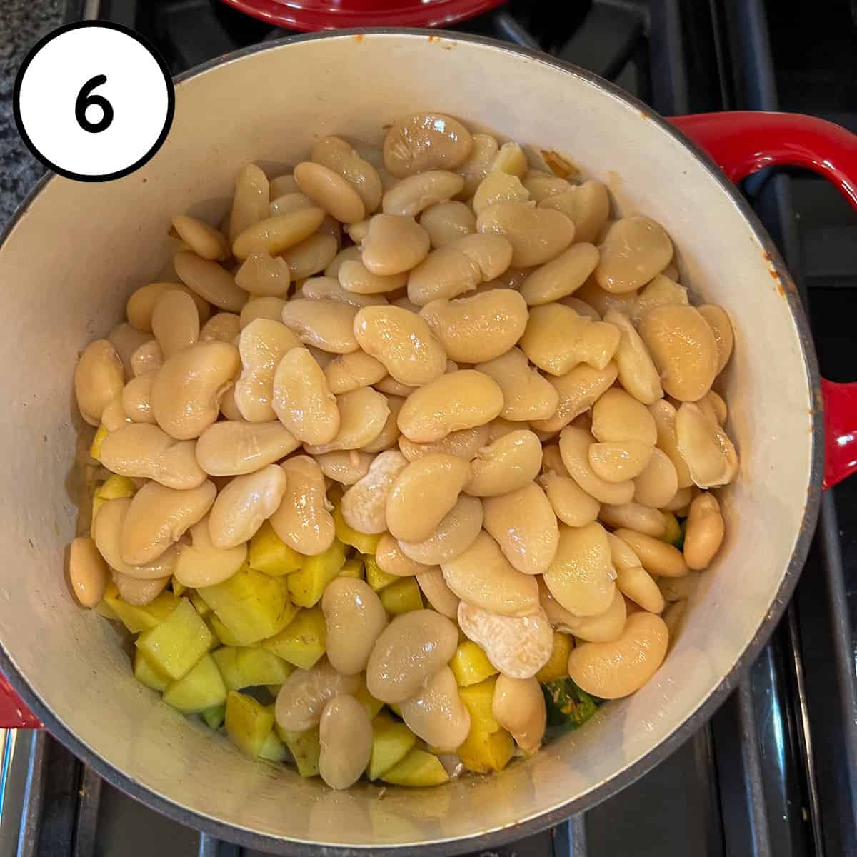 Cooked butter beans added to the pot with veggies and mushrooms.