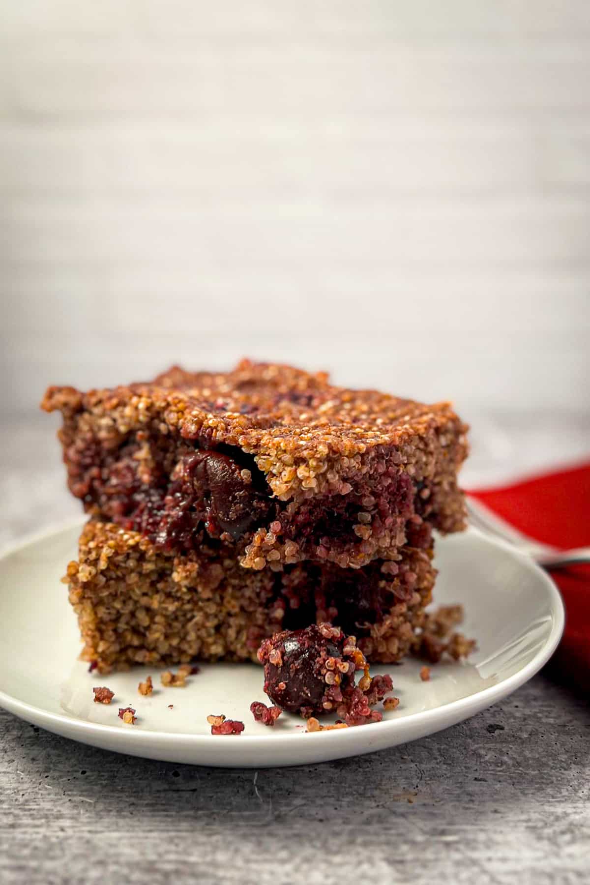 Two stacked slices of cherry quinoa breakfast bake on a plate.
