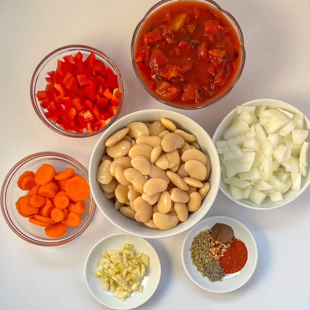 The ingredients for butter bean stew: butter beans, carrots, onion, bell pepper, garlic, diced tomatoes and spices.