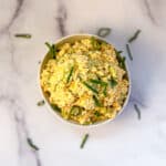 Curried tofu salad in a bowl with sliced green onion on top.
