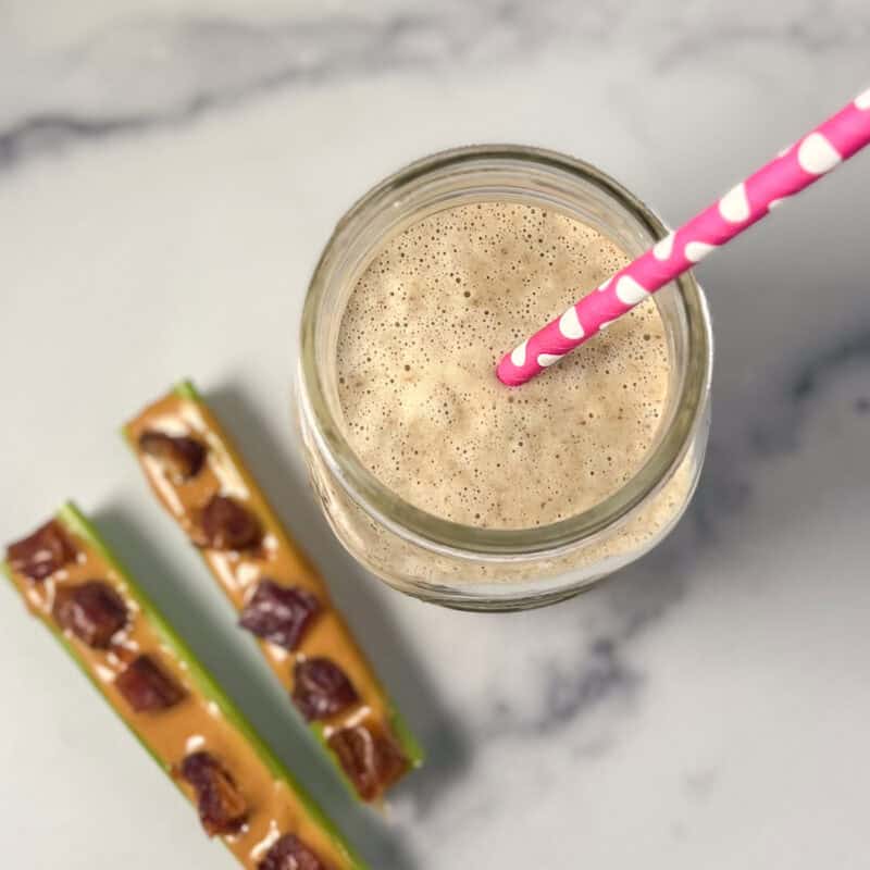 Ants on a log smoothie with two celery stalks with peanut butter and chopped dates.