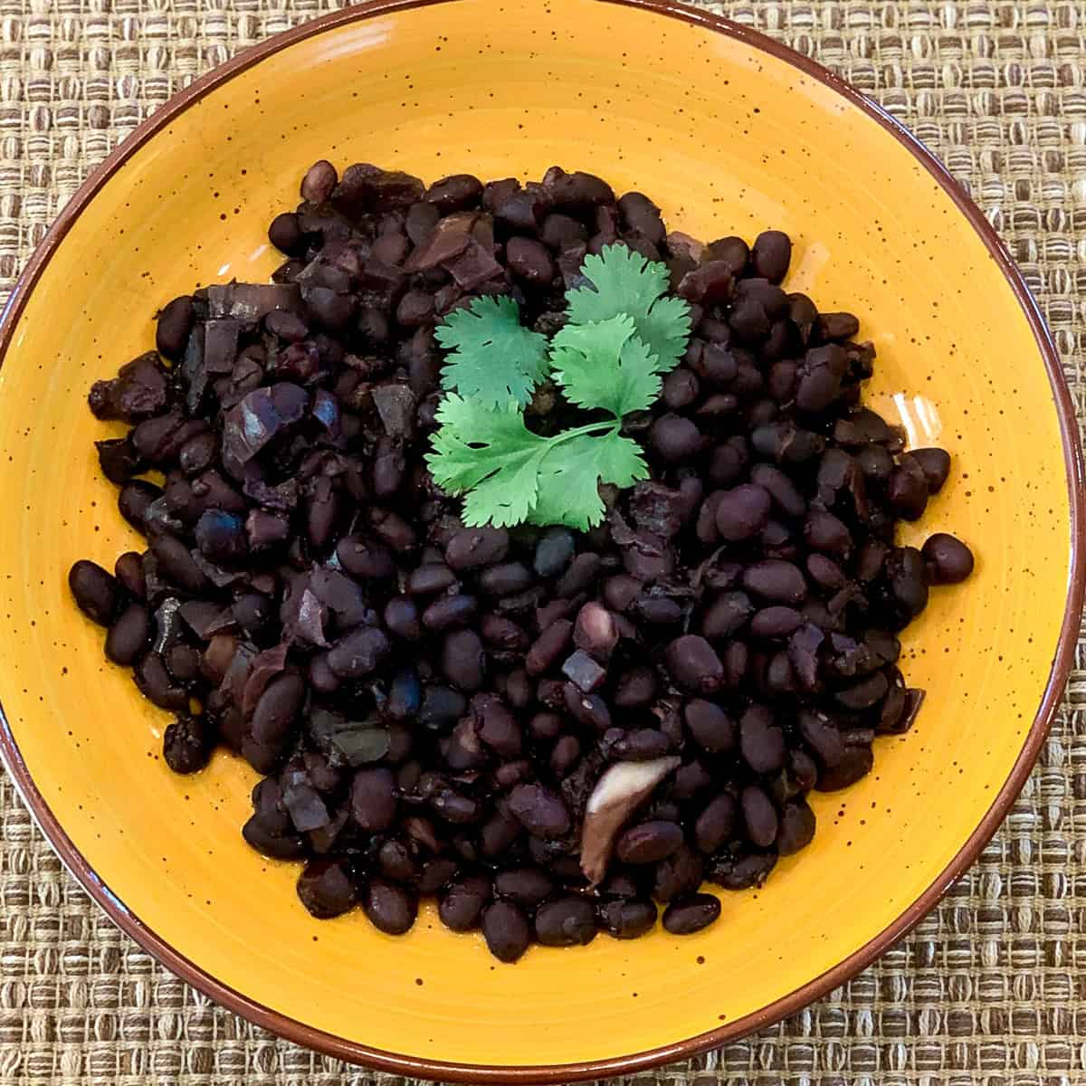 Cuban black beans garnished with fresh cilantro in a bowl.