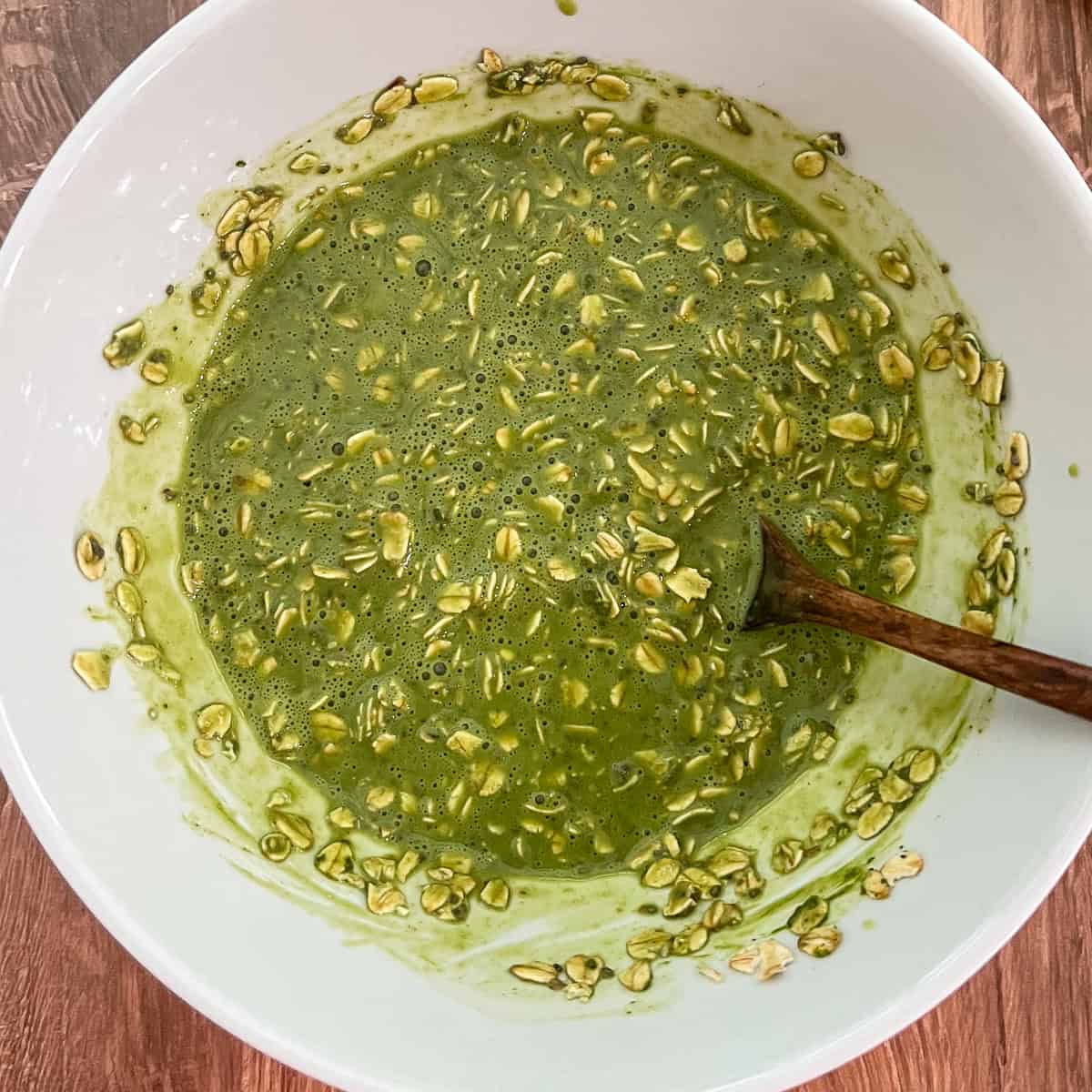 Matcha overnight oats mixture that has been stirred in a mixing bowl.