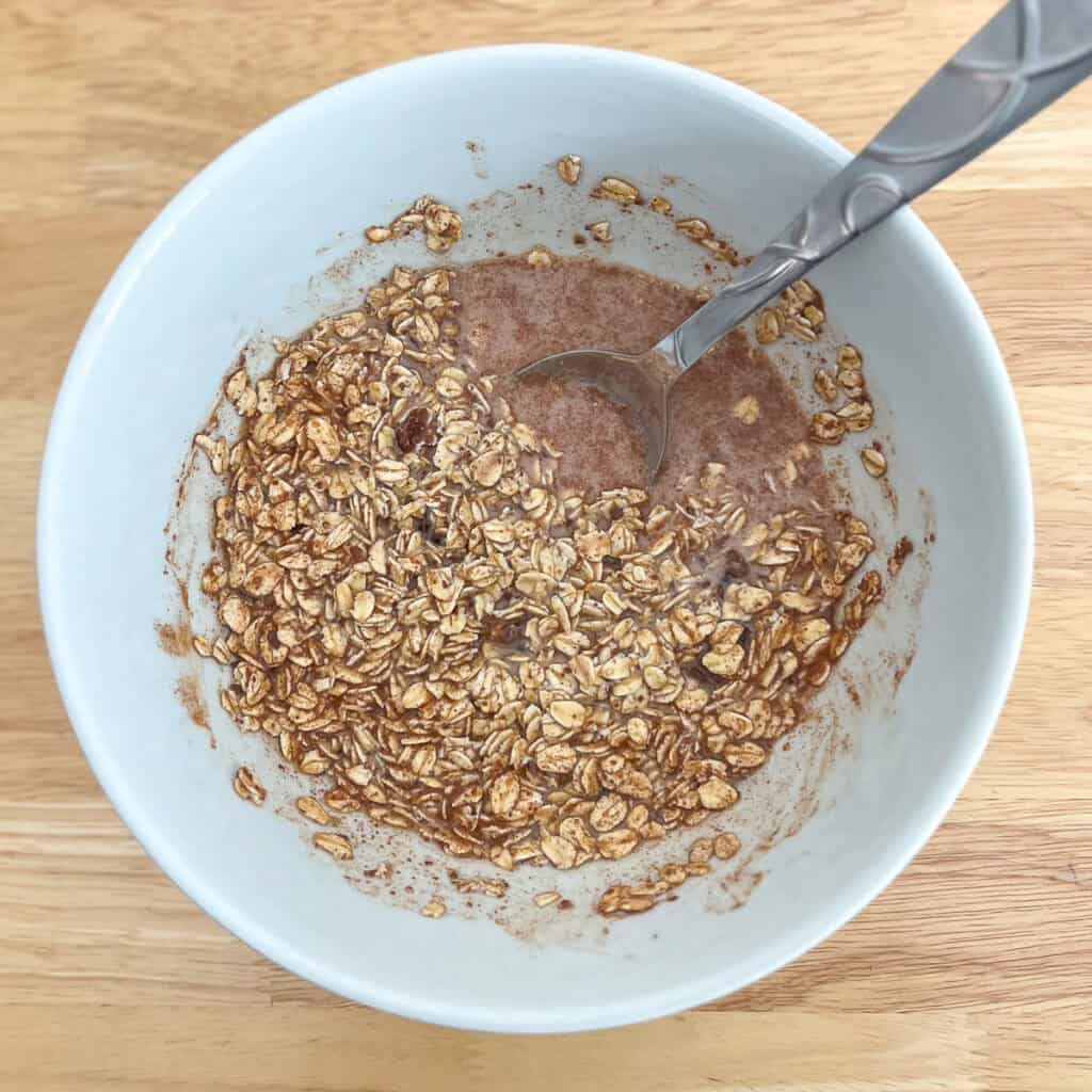 Oatmeal mixture in a bowl with a spoon.