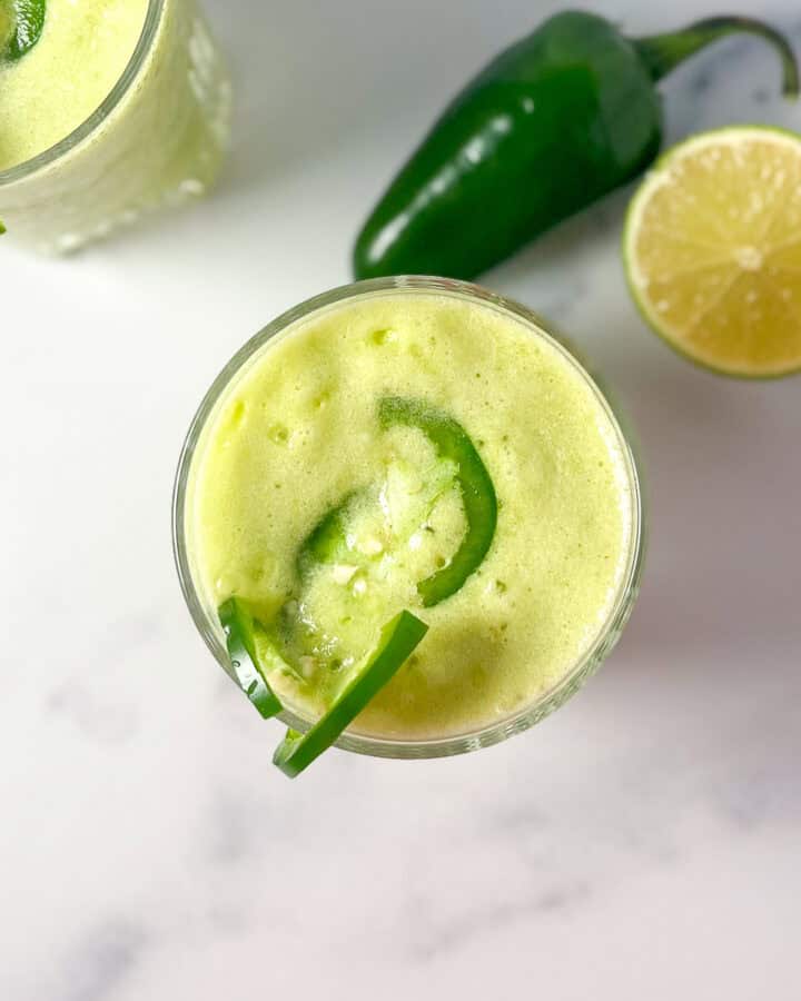 Spicy margarita mocktail with sliced jalapeno floating on top.