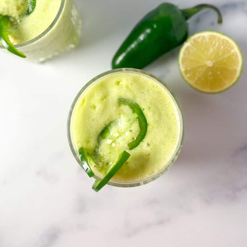 Spicy margarita mocktail with sliced jalapeno floating on top.