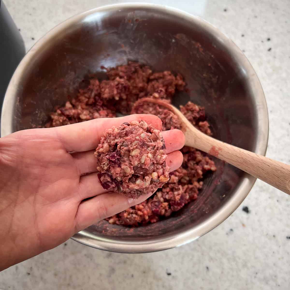 A woman's hand forming a small vegan burger slider patty.