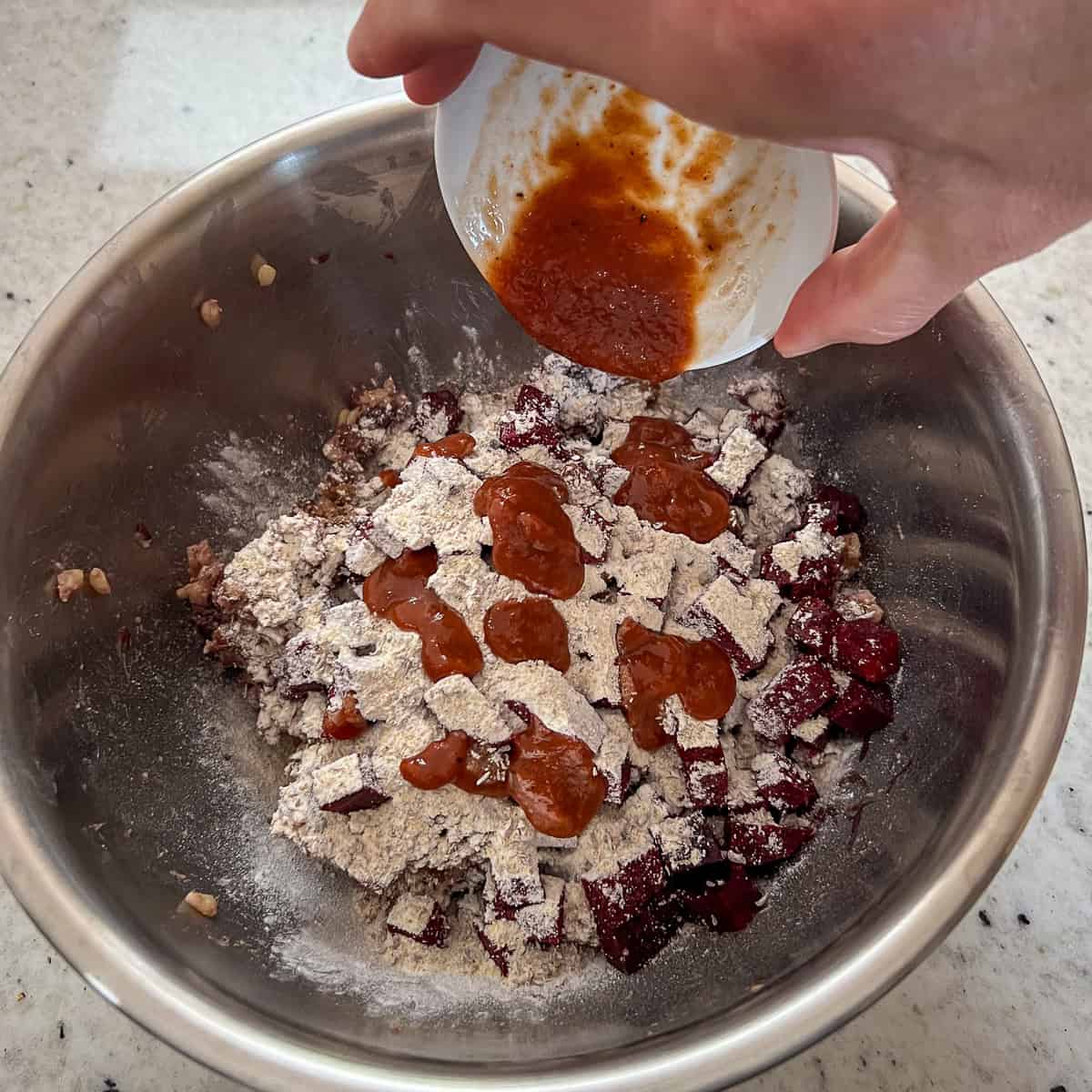 Barbeque sauce being dolloped over the vegan slider mixture.