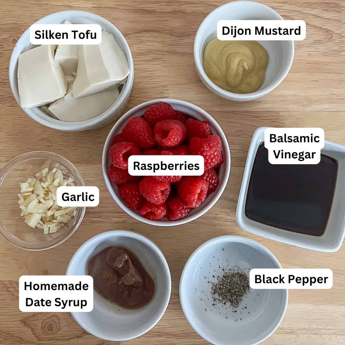 Ingredients for this dressing: silken tofu, fresh raspberries, Dijon mustard, balsamic vinegar, garlic, date syrup, and black pepper.