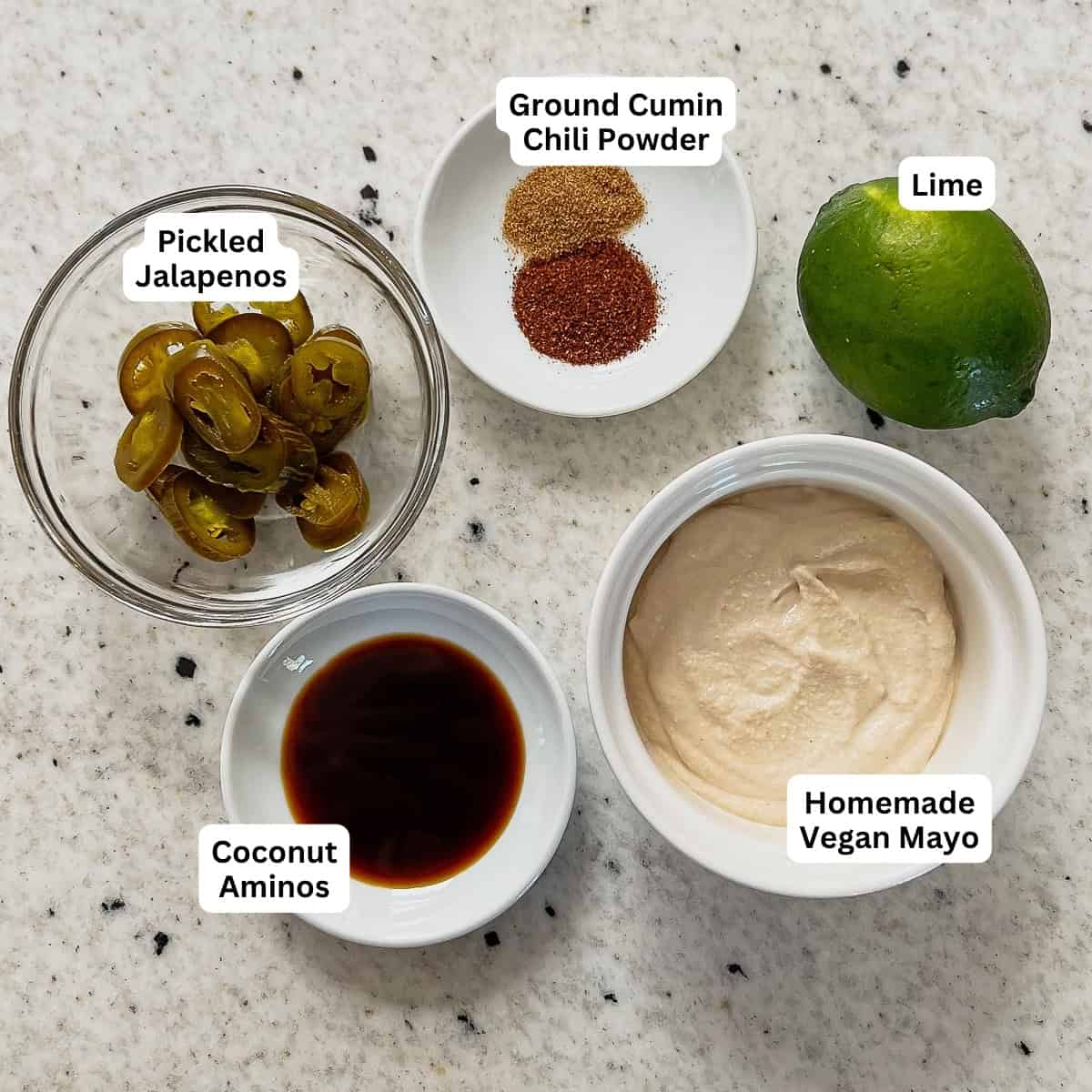 Ingredients for vegan jalapeno lime aioli: pickled jalapenos, chili powder, cumin, coconut aminos, vegan mayo and lime.
