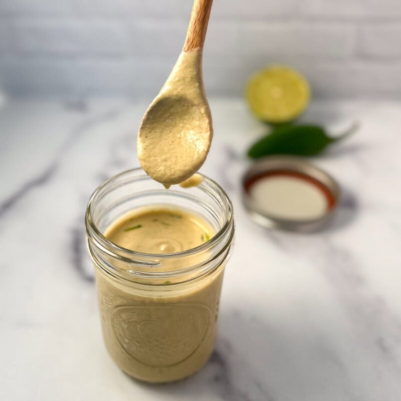 Jalapeno lime aioli in a mason jar with wooden spoon.