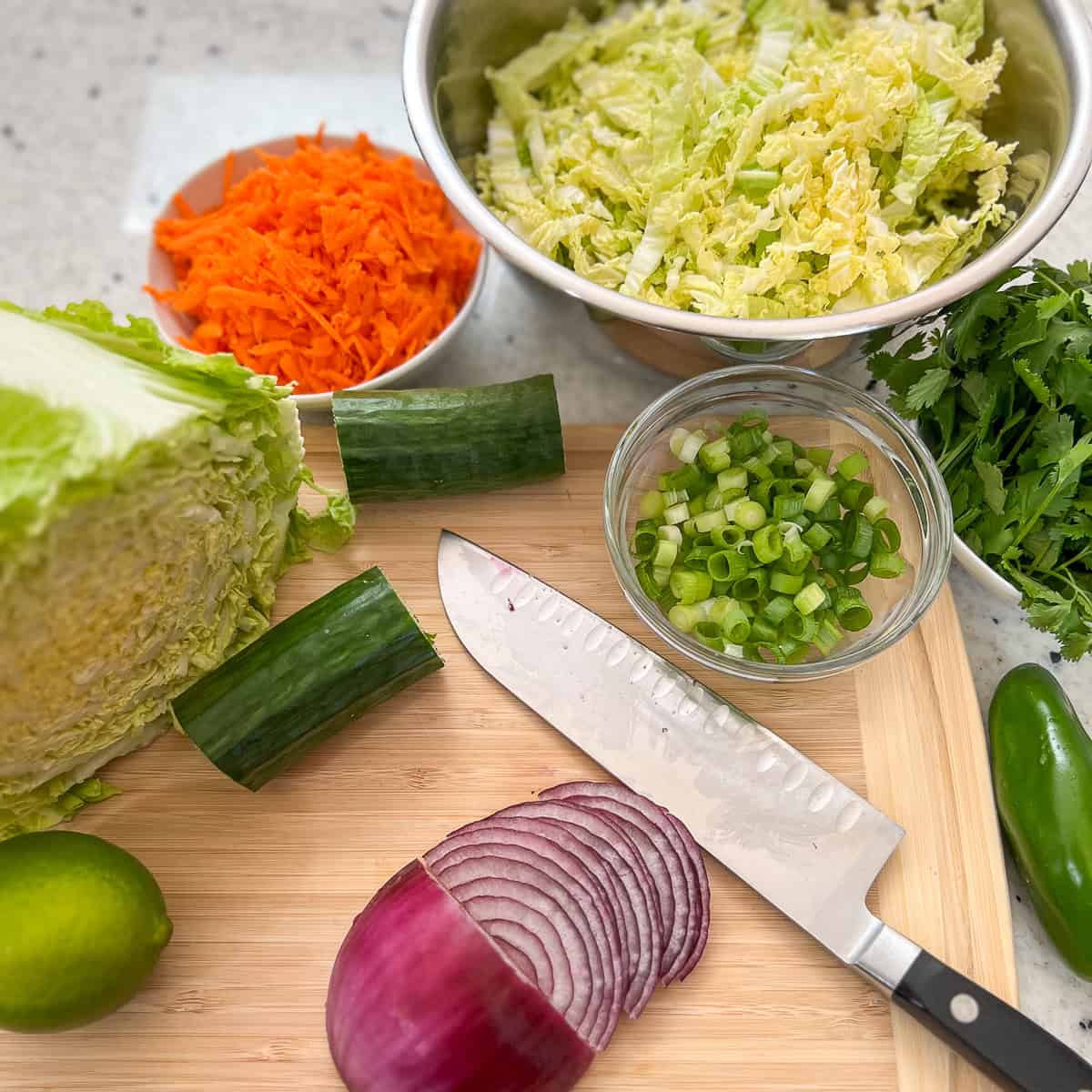 Veggies for the banh mi salad being chopped on a cutting board.