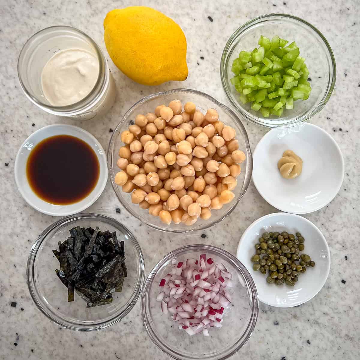 Ingredients for vegan chickpea tuna salad: chickpeas, vegan mayo, celery, coconut aminos, Dijon mustard, capers, red onion and nori seaweed.