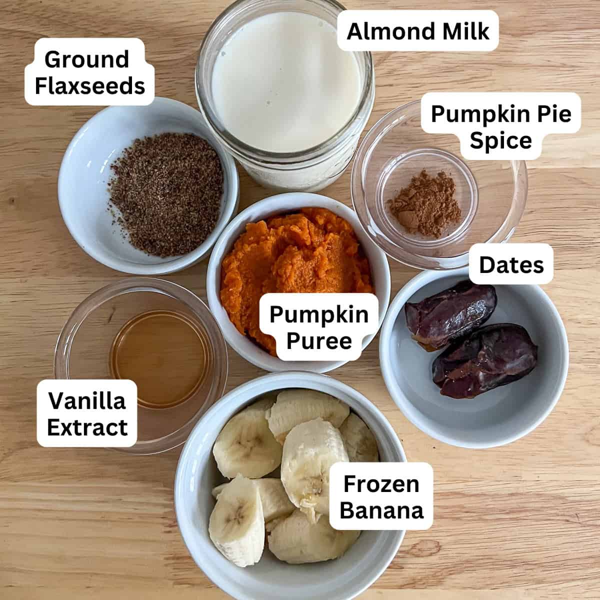 Ingredients for pumpkin spice smoothie: pumpkin puree, banana, almond milk, dates, ground flaxseeds, pumpkin spice, and vanilla.