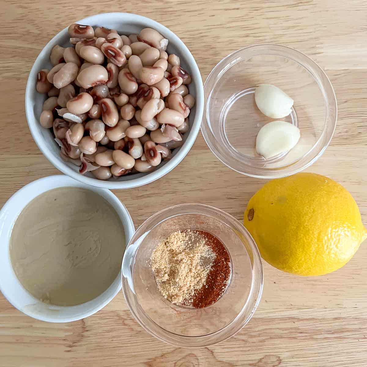 Ingredients for black eyed peas hummus: cooked black eyed peas, garlic, lemon, tahini, and spices.