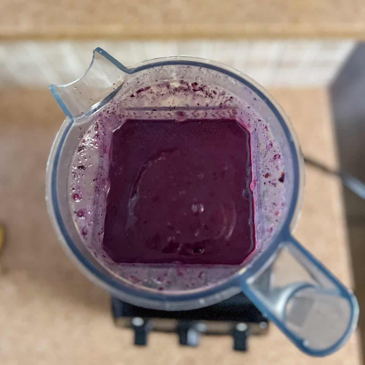 Top view of the blueberry peanut butter smoothie that has been blended in a blender.