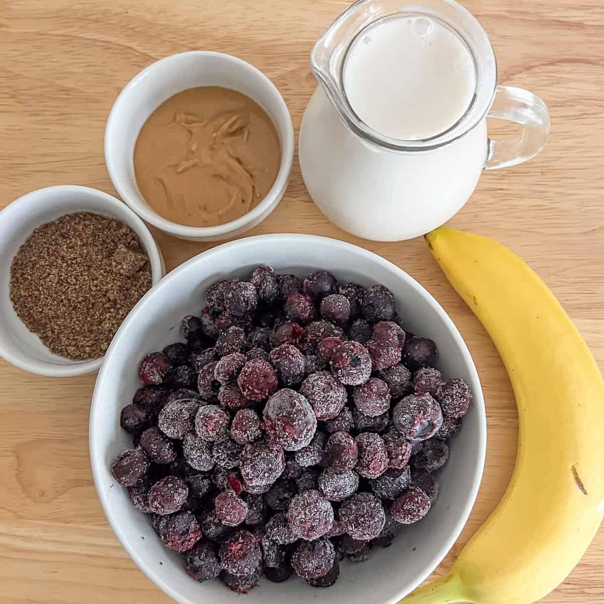 Ingredients for the blueberry peanut butter smoothie: frozen blueberries, peanut butter, plant-based milk, ground flaxseeds and banana.